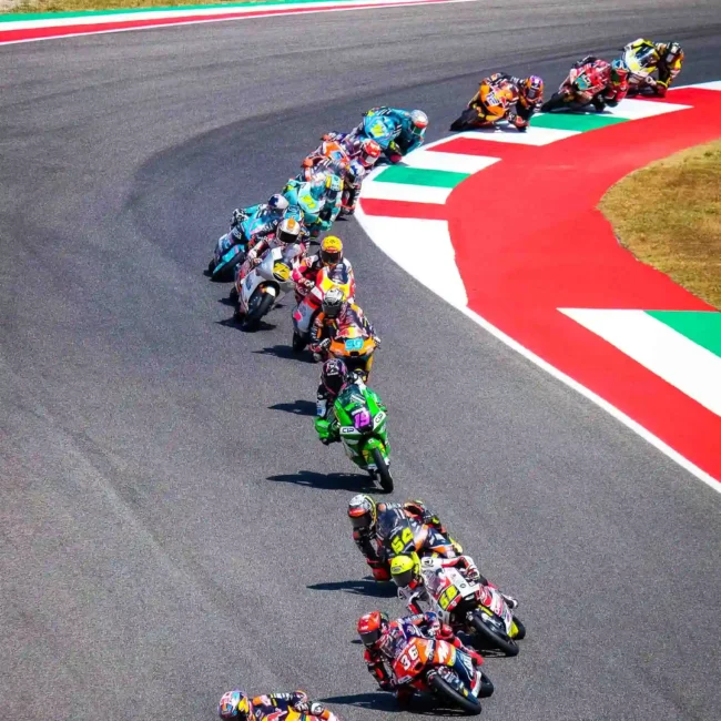 Gruppo di motociclette in gara su una curva di motogp, fotografato da fotografo eventi Torino.