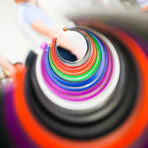Foto professionale di un'esposizione di braccialetti colorati disposti a spirale, ideale per un fotografo per Instagram che crea immagini dinamiche per siti web.