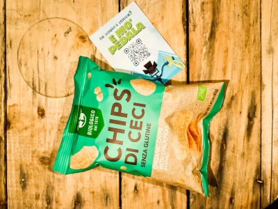 Scatto professionale di un pacchetto di chips di ceci biologiche su un tavolo di legno, perfetto per un fotografo per Instagram e foto profilo LinkedIn.